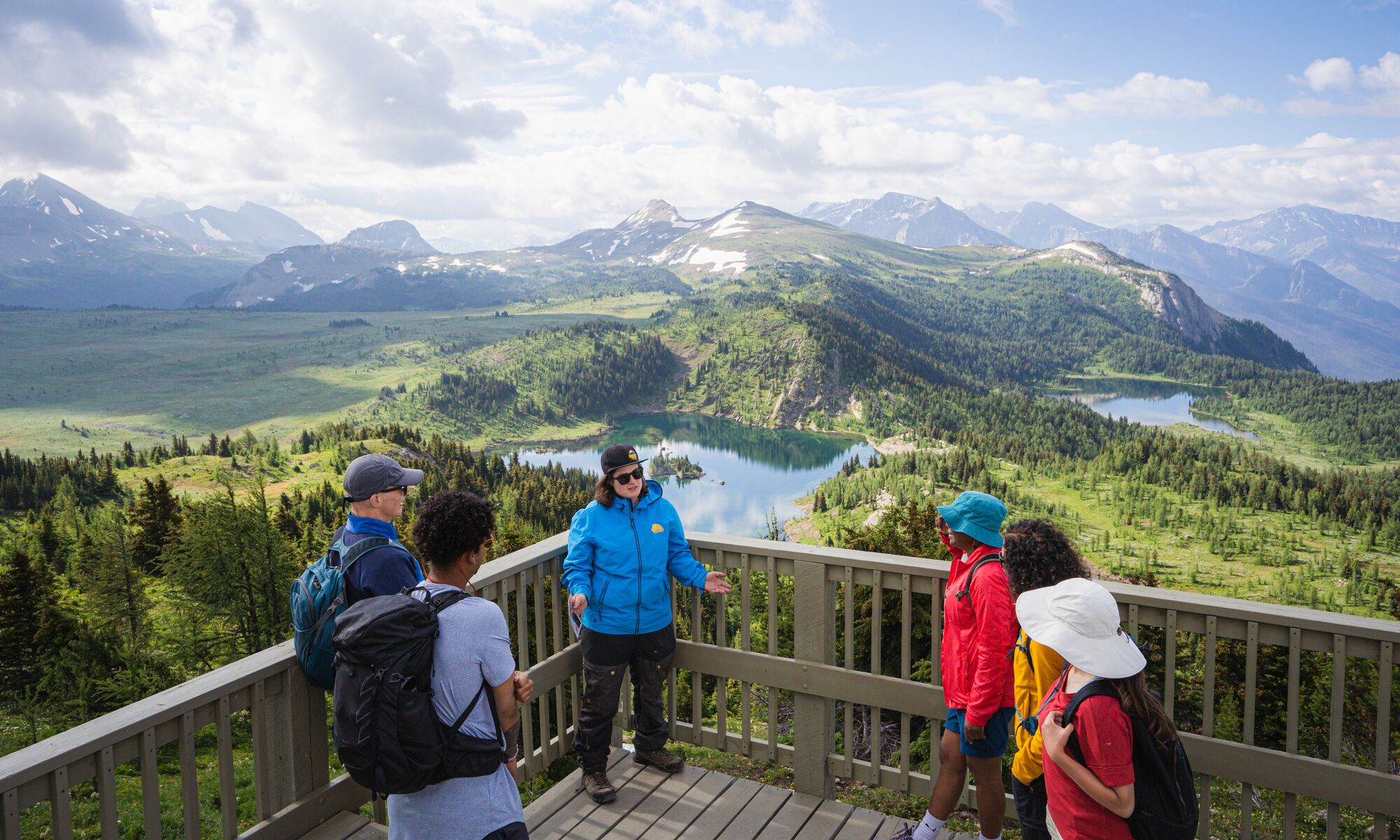 A hiking guide at Sunshine Meadows talks to a group of people at the Standish Lookout viewpoint.